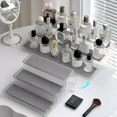 Luxurious perfume bottles arranged on a white vanity table with a mirror and makeup brush, exemplifying elegance and beauty, available at Monalisa Store for premium cosmetic and fragrance shopping.