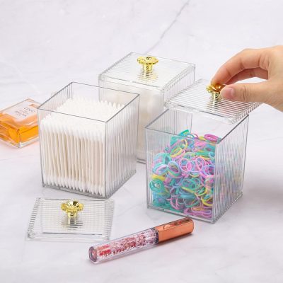 Clear acrylic storage boxes with gold-tone lids for organizing cosmetic and skincare tools at Monalisa Medical Spa, perfect for maintaining a tidy and stylish beauty or opt clinic environment.