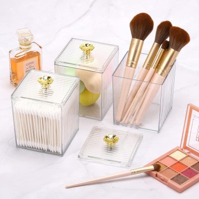 Elegant makeup brushes and cosmetic storage containers with gold accents for beauty and skincare organization. Perfect for a professional or personal beauty routine.
