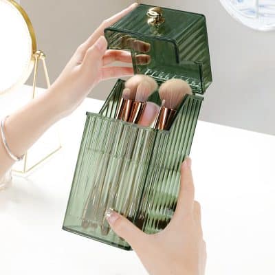 Eco-friendly makeup brush holder and organizer, transparent green acrylic with storage compartments for beauty tools.