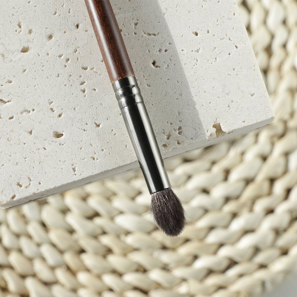 Luxury makeup brush on a textured white surface at Monalisa Store, ideal for professional beauty and skincare application, perfect for enhancing beauty routines.