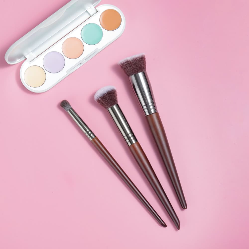 Professional makeup brushes with wooden handles and soft bristles on a pink background, ideal for beauty, cosmetic application, and skincare routines.