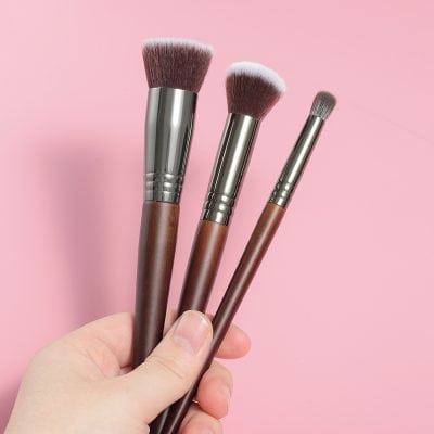 Soft pink makeup brushes set with wooden handles and synthetic bristles for cosmetic application, ideal for beauty enthusiasts and professional makeup artists.