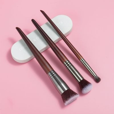 Soft makeup brushes with wooden handles and pink-tipped bristles on a light pink background, ideal for beauty and cosmetic applications at Monalisa Store.