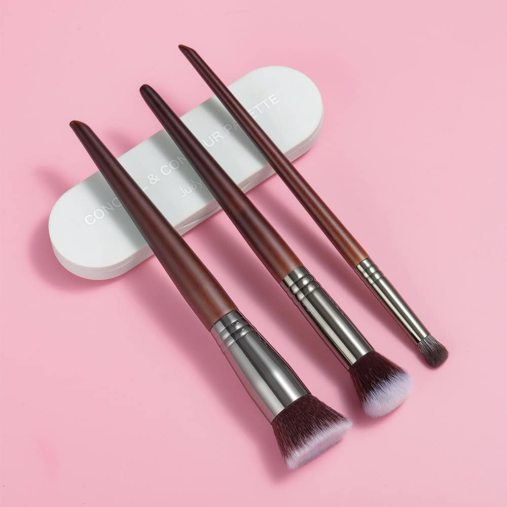 Soft makeup brushes with wooden handles and pink-tipped bristles on a light pink background, ideal for beauty and cosmetic applications at Monalisa Store.