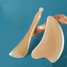 Handmade ceramic eyeglass holders shaped like human ears on a blue background.