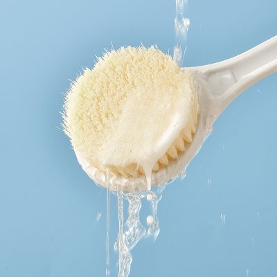 Soft natural sponge with mild cleansing liquid on a blue background, ideal for facial skincare and cleansing routines.