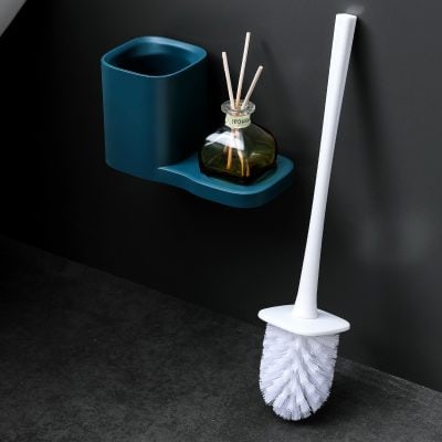 Blue wall-mounted bathroom storage unit with reed diffuser, toilet brush, and cleaning brush for modern bathroom organization and hygiene solutions in monochrome design.