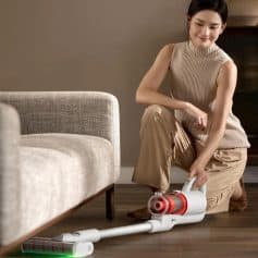 Lightweight cordless vacuum cleaner on hardwood floor with woman cleaning living room, modern home cleaning, efficient and portable vacuum for everyday use, Monalisa Medical.