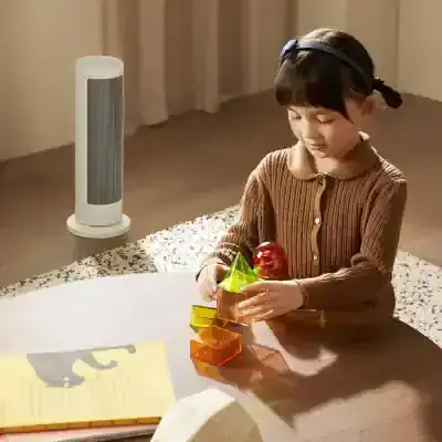 Colorful children's educational building blocks arranged on a wooden table with a girl playing, indoor setting with air purifier in the background.