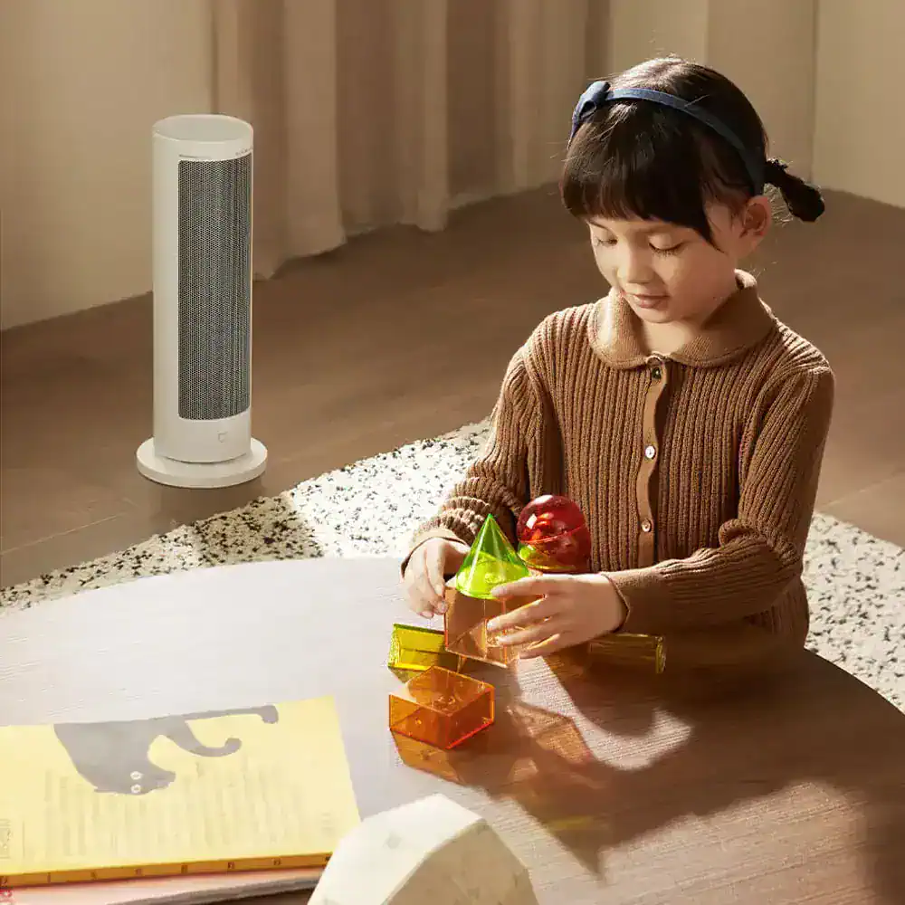 Colorful children's educational building blocks arranged on a wooden table with a girl playing, indoor setting with air purifier in the background.