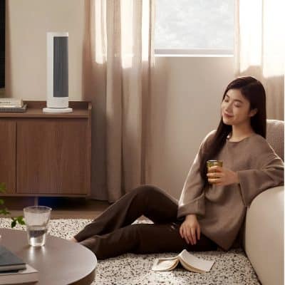 Relaxing woman enjoying air purifier at home, cozy living room, modern air cleaner, fresh air environment, healthy home air quality, comfortable interior, peaceful lifestyle, indoor air purification, Monalisa Store.