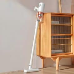 Cordless stick vacuum cleaner for home cleaning, displayed next to wooden cabinet, modern lightweight design, ideal for fast and efficient cleaning, Monalisa Store opt light vacuum.