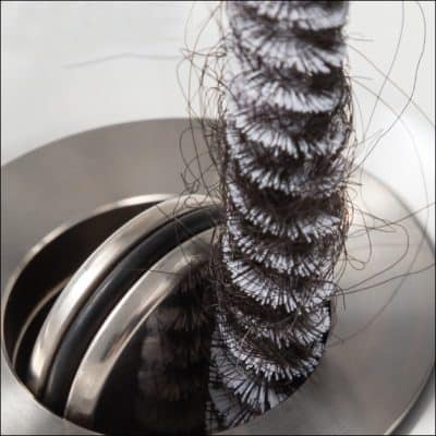 Close-up of a hairbrush bristle brush with hair strands on a professional cleaning machine, showcasing hygiene and cleanliness for optimal scalp health and hair care solutions.