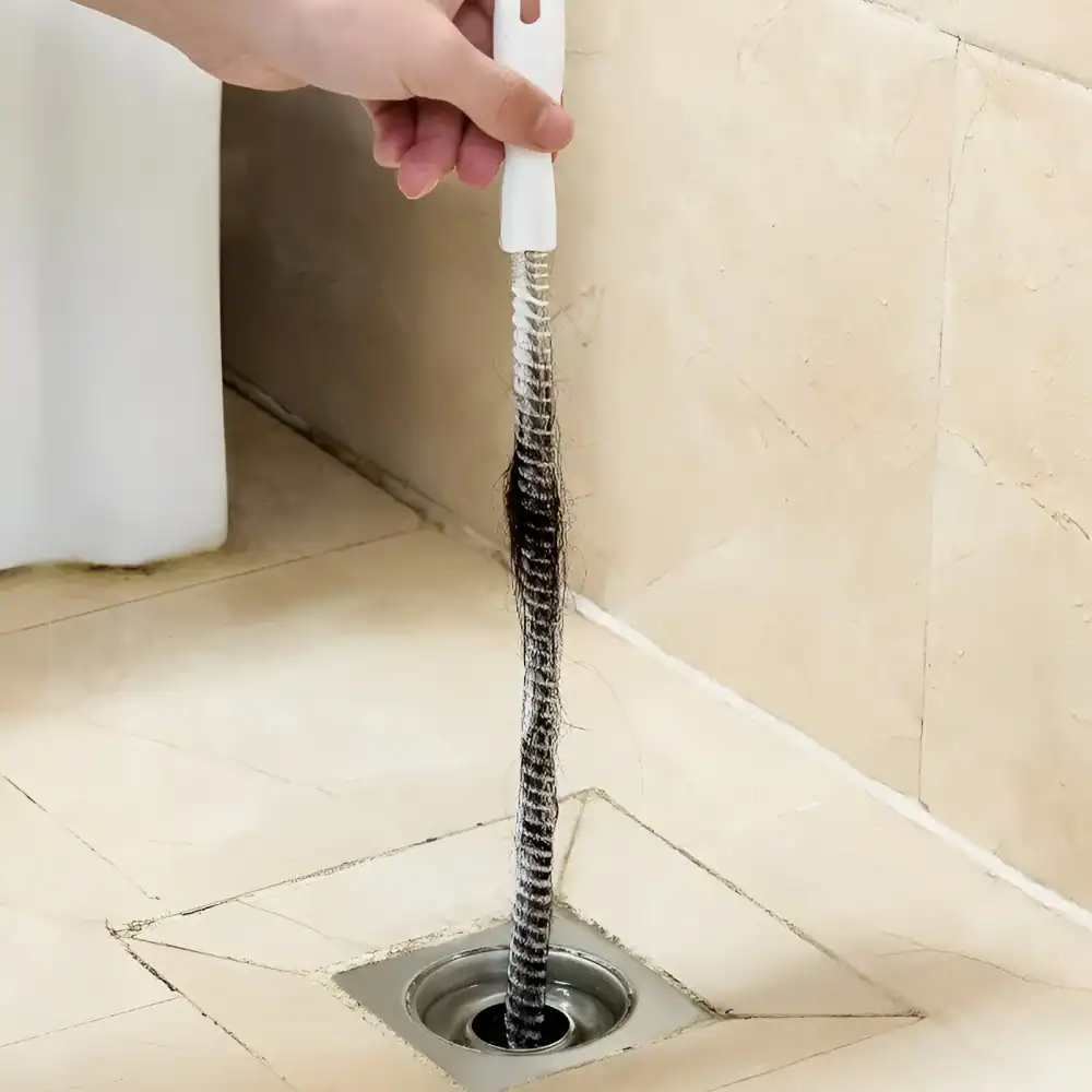 Flexible drain snake cleaning tool for unclogging kitchen or bathroom drains, easy to use for plumbing maintenance.