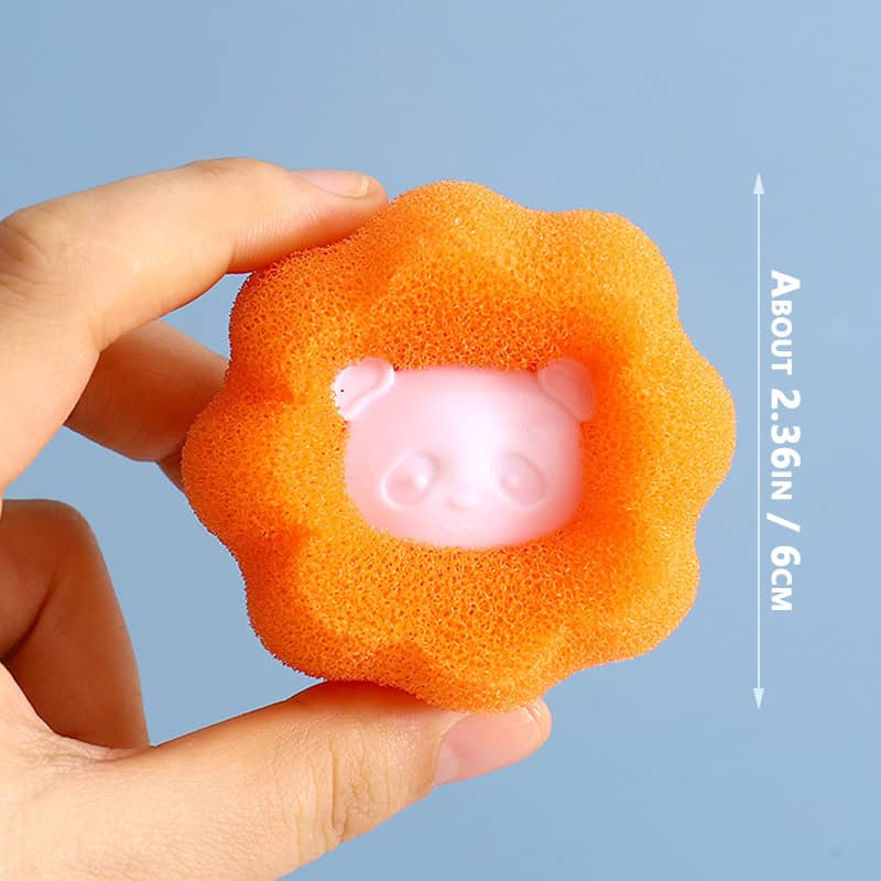 Whimsical orange sponge with a cute baby face design, used for cleaning or skincare, measuring approximately 2.3 inches/6 cm in diameter, ideal for skincare routines and facial cleansing.