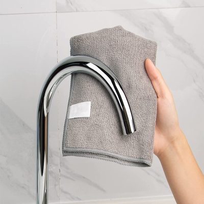 Meticulous cleaning with microfiber cloth on modern chrome faucet in bathroom setting.