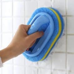 Cleaning wall tiles with a blue scrub brush at Monalisa Store.