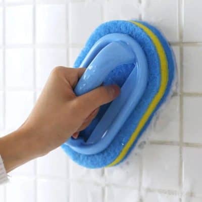 Cleaning wall tiles with a blue scrub brush at Monalisa Store.