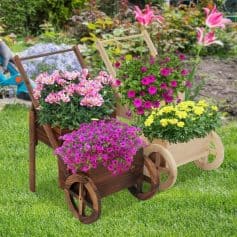Colorful flower arrangements in wooden carts on a lush garden lawn, perfect for enhancing outdoor spaces and adding vibrant color with seasonal blooms. Ideal for garden decor and floral displays.