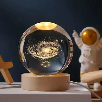 Galaxy-themed decorative crystal ball with gold accents and a celestial design, perfect for modern home decor and meditation spaces.