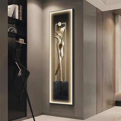 Elegant modern wall art sculpture of a stylized woman with sleek, metallic finish and backlit frame, creating luxury ambiance in a contemporary interior.