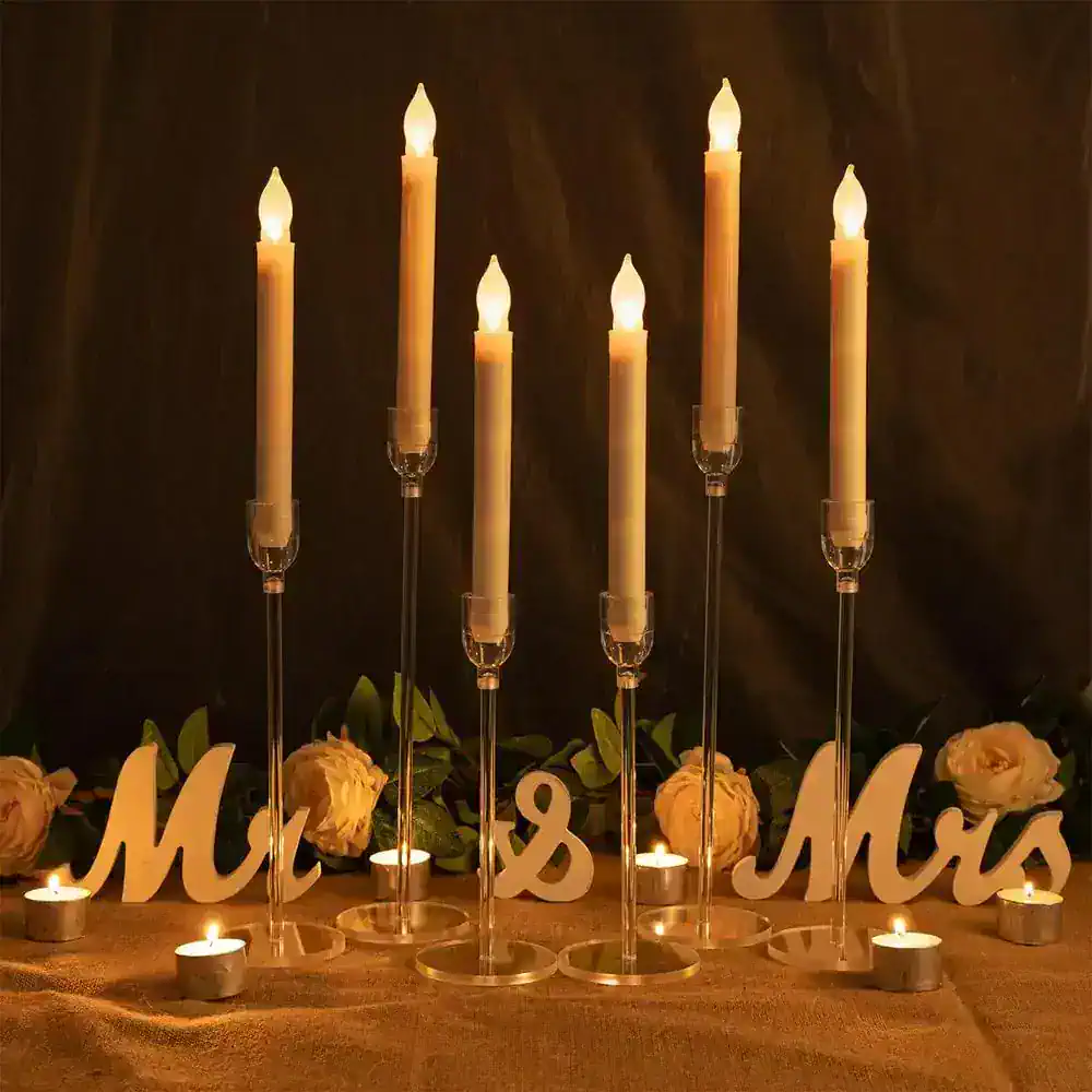 Elegantly lit candles for wedding decor centerpiece with "Mr & Mrs" sign, surrounded by white roses, creating a romantic and warm ambiance for special occasions and celebrations.