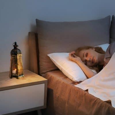 Luxurious bedroom scene featuring a woman peacefully sleeping with elegant decor, warm lighting, and comfortable bedding, perfect for relaxation and restful sleep.