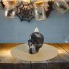 Skull-shaped candle holder with a white candle on top, Halloween-themed Halloween decor, spooky ambiance, black and white candle, decorative skull for Halloween parties.