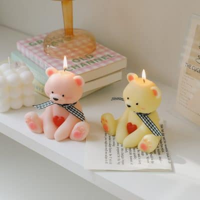 Pink and yellow teddy bear-shaped candles with hearts, decorative candles highlighting Monalisa Store's unique collection of gift candles and home decor accessories for a cozy, charming ambiance.