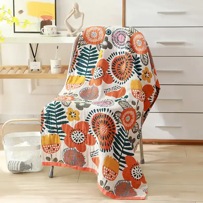 Vibrant floral patterned throw blanket draped over modern chair in cozy home setting, perfect for adding color and warmth to living spaces. Bright colors, stylish design, and versatile decor accent.