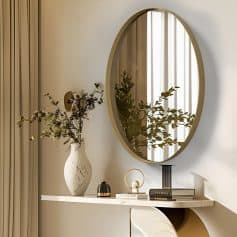 Elegant interior decor featuring a large oval mirror, decorative vases with dried flowers, and stylish accessories on a sleek white console table, creating a luxurious and modern ambiance for Monalisa Store.