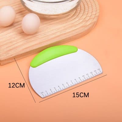Soft green pastry scraper with silicone handle on a peach background, ideal for baking and kitchen use.