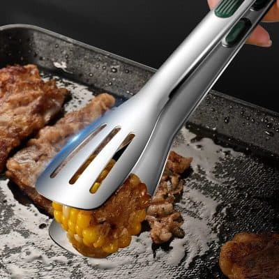 Sleek stainless steel electric tongs gripping corn on the cob in a modern kitchen setting.