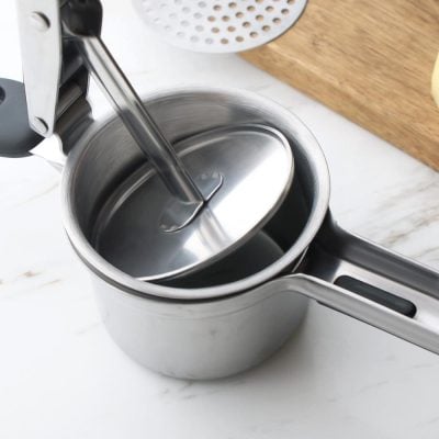 Stainless steel milk frother on marble countertop, ideal for café-quality coffee drinks, easy to use for home brewing, professional kitchen equipment, Monalisa Store.