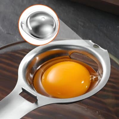 Crack egg in stainless steel egg separator for clean yolk separation, kitchen cooking tool, professional food prep device, ideal for baking and breakfast recipes.
