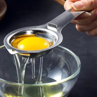 Fresh cracked egg being separated into a glass bowl, highlighting egg preparation for cooking or baking at Monalisa Store for culinary enthusiasts.
