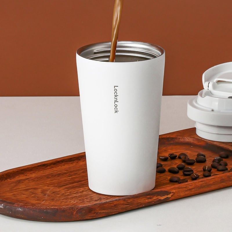 Reusable white insulated coffee tumbler with "Locket Lock" branding on a wooden tray, coffee beans, and a white lid, ideal for office and travel use.