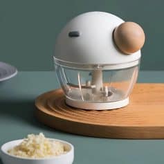 Mini food chopper with wooden base, perfect for preparing small amounts of ingredients in the kitchen. Compact design ideal for chopping vegetables, herbs, or nuts with ease.
