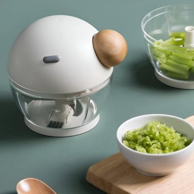 Brightener face care device on a light green surface with bowls of chopped vegetables and a wooden spoon, showcasing innovative skincare tools at Monalisa Store.