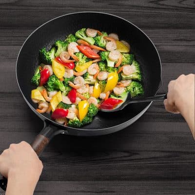 Fresh shrimp and colorful bell peppers stir-fried in a black wok for a healthy meal, emphasizing fresh ingredients and vibrant dish presentation.