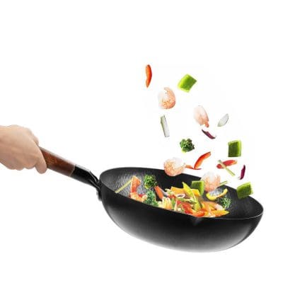 Fresh vegetables and shrimp being tossed in a wok for healthy cooking and meal prep.