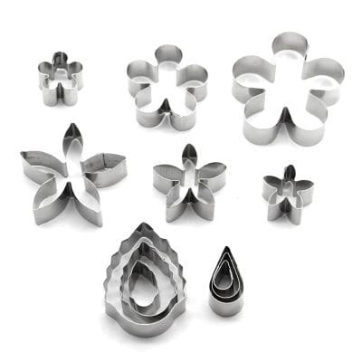 Set of metal cookie and fondant cutters in floral and geometric shapes, perfect for baking and cake decoration. Durable stainless steel cutters with various sizes for versatile culinary design.