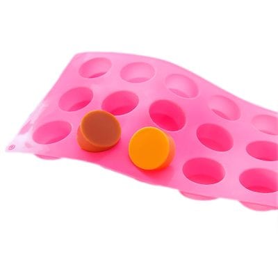 Pink silicone pill organizer with multiple compartments for daily medication storage, featuring two round pills placed on it. Ideal for organizing vitamins and tablets, perfect for home or travel.