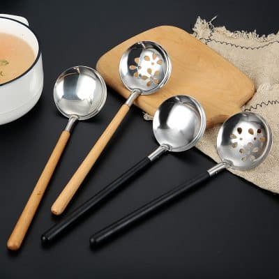 Stainless steel slotted and solid scoop spoons with wooden and black handles, ideal for kitchen and restaurant use.