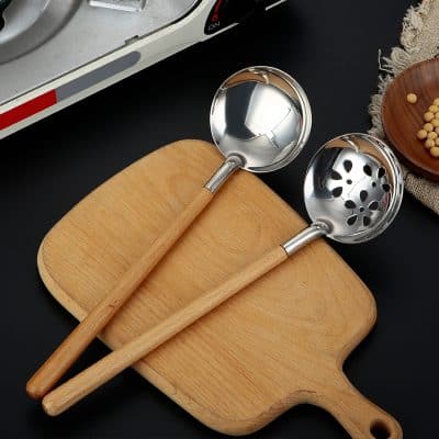 Stainless steel kitchen ladles with wooden handles on a wooden cutting board, perfect for cooking and serving. Monalisa Store offers high-quality kitchen utensils for home chefs and professional kitchens.