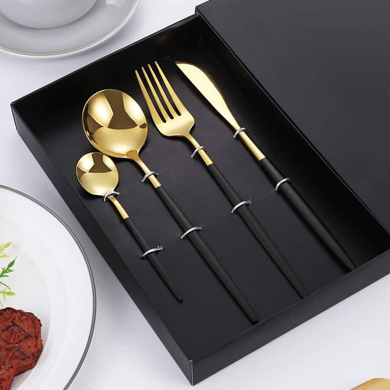 Shiny gold and black cutlery set including spoon, fork, and knife in elegant black gift box, ideal for modern dining and special occasions, stylish tableware accessories.