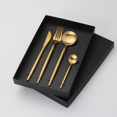 Elegant gold cutlery set including knife, fork, spoon, and teaspoon in stylish black presentation box, perfect for upscale dining and kitchen decor.