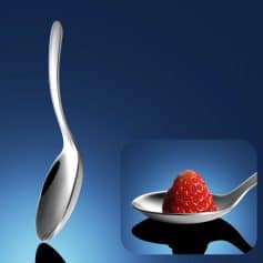 Stainless steel spoon with a sleek, curved design and a close-up of a fresh strawberry on a matching spoon, showcasing elegant and high-quality kitchenware for optometrists and eyewear enthusiasts.