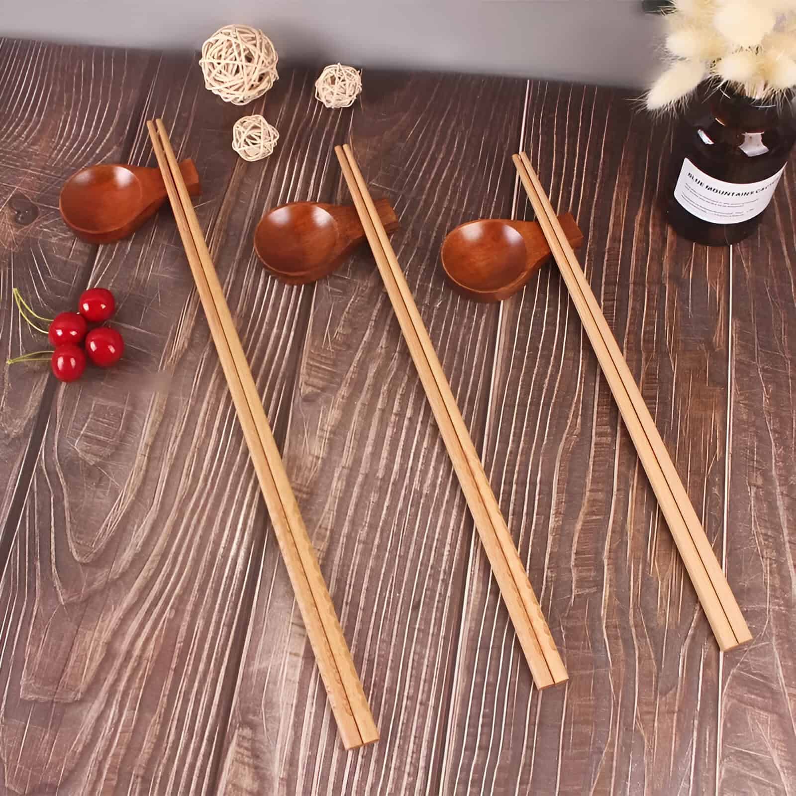 Elegant wooden chopsticks, matching spoons, and decorative accents on a stylish wooden dining table, ideal for enhancing your dining experience at Monalisa Store.